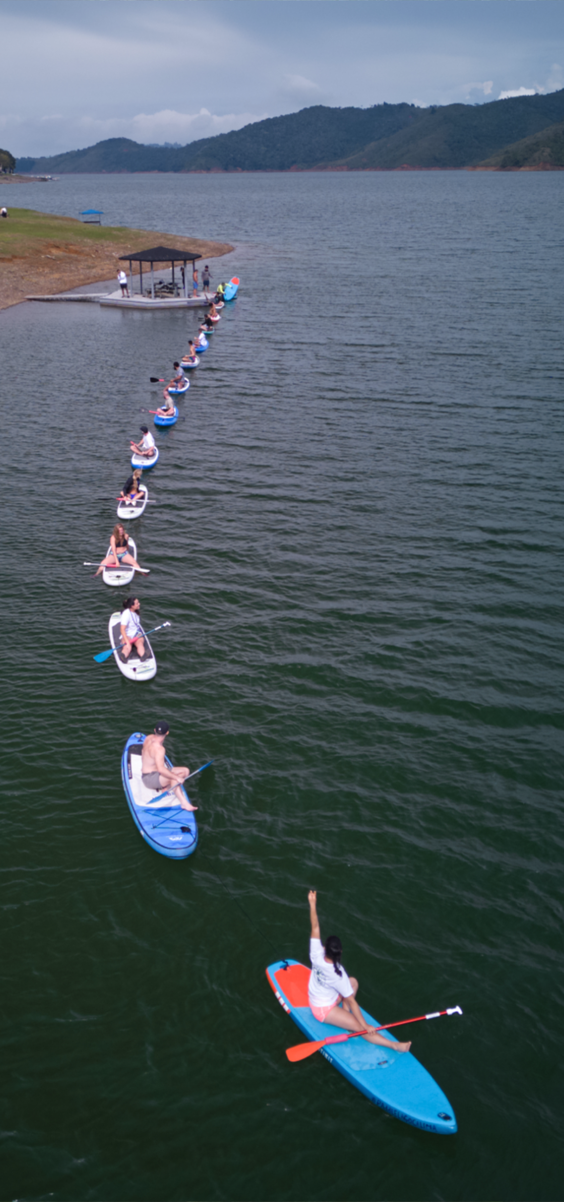 Participants paddle boarding on a serene lake near BJJ Camp XP, showcasing the enjoyable outdoor activities available at the camp that complement their Jiu-Jitsu training.