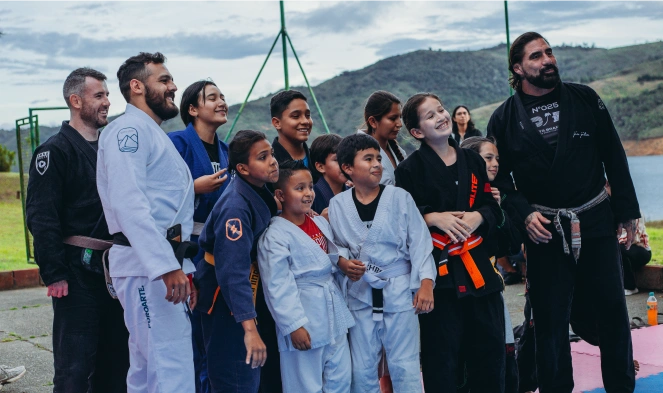 Leonidas Benjumea posing with children and fellow Jiu-Jitsu practitioners during a training event near Calima Lake, Colombia.