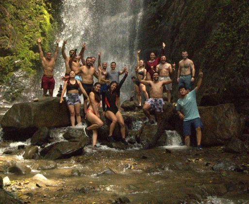 BJJ Camp Adventure at the Waterfalls Group of BJJ Camp participants celebrating in front of a natural waterfall.