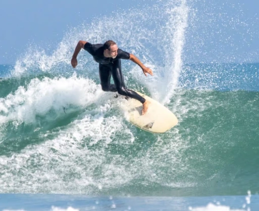 BJJ Camp Adventure with Surf Sessions Included BJJ Camp participant surfing a wave during the camp’s surf adventure session.