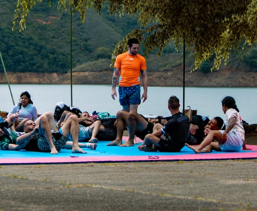 BJJ Camp Training by the Lake in Calima Participants of BJJ Camp practicing Brazilian Jiu-Jitsu on mats by the tranquil shores of Lake Calima.
