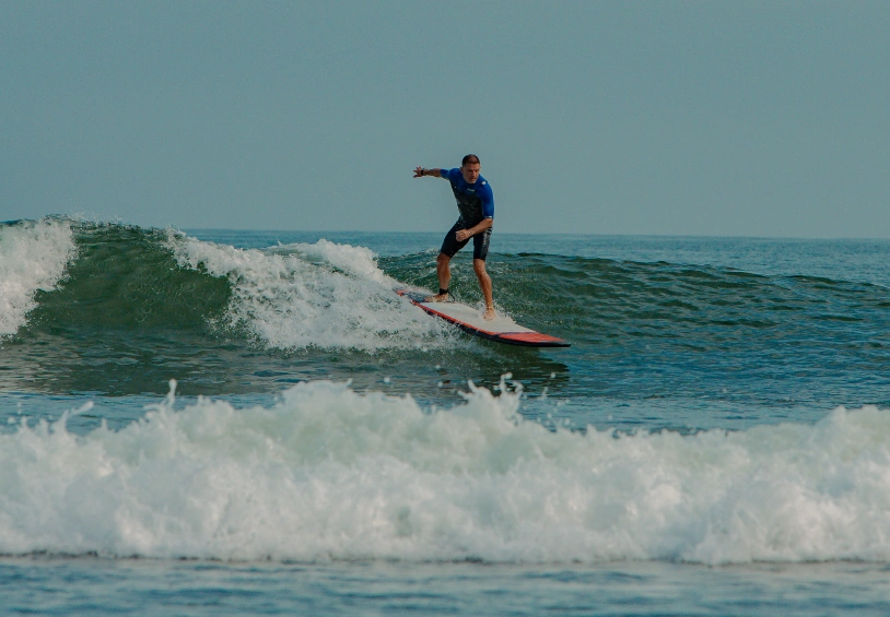 Surfer riding a wave in Peru during a Brazilian Jiu Jitsu Camp in Peru experience.