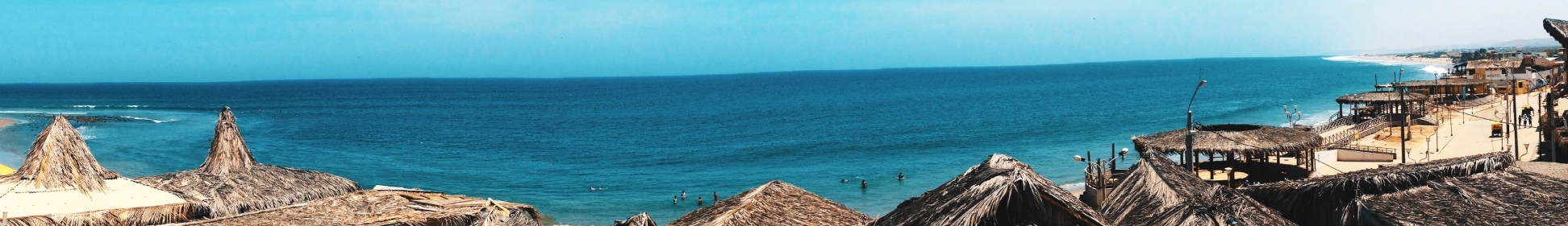 Oceanfront view in northern Peru with beach huts and coastline, home of a Brazilian Jiu Jitsu Camp in Peru.